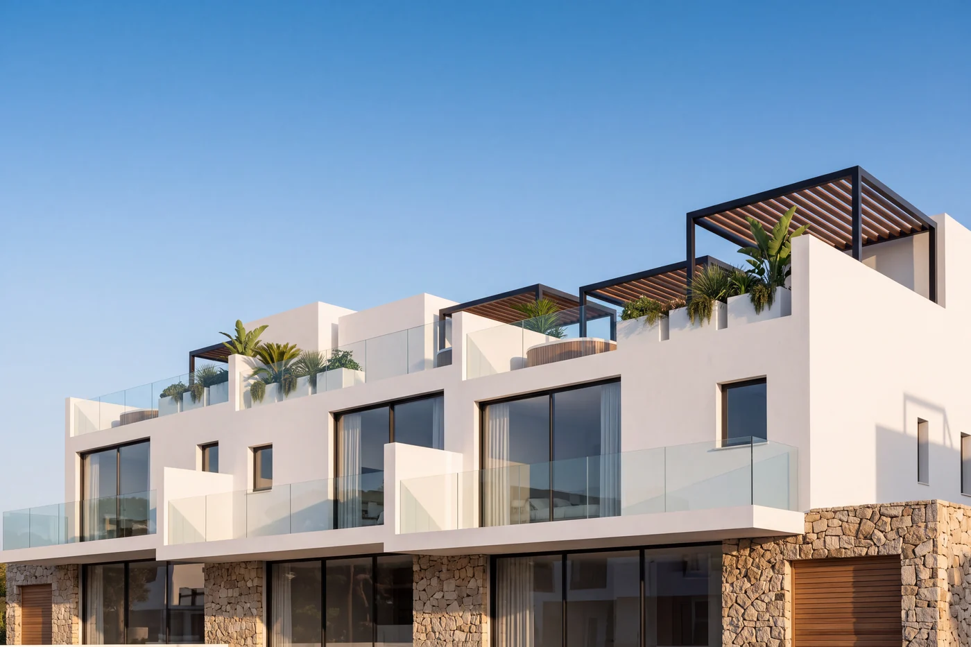 Casas de obra nueva en la Costa del Sol vistas desde el jardín, con pérgolas y terrazas contra el cielo (imagen ilustrativa)